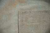 Reverse corner of a vintage Oushak carpet detailing the hand-knotted foundation and side cord finish.