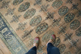 Distressed vintage Oushak carpet with 'elephant footprint' motif, abrashes, and faint foundation.