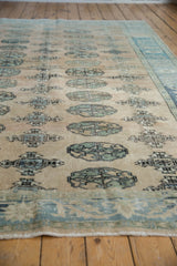 Distressed Oushak rug's geometric floral gul motifs in muted sand and sea foam tones.
