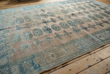 Distressed vintage Oushak carpet corner with geometric guls, abrashes, and faint foundation.