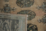 Vintage distressed Oushak rug showing sand field, sea foam guls, and woven foundation.