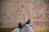 Distressed vintage Sivas carpet with soft raspberry, chartreuse, and mint blue floral patterns.