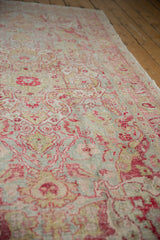 Distressed vintage Sivas carpet with raspberry, chartreuse, and mint blue floral vinery motifs.