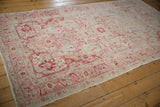 Distressed Sivas carpet corner shows worn raspberry, mint green, and blue motifs.