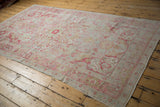 Intact side selvage and faded raspberry pile texture of the distressed Sivas carpet.