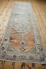 Stepped diamond and geometric floral motifs in pale tangerine and charcoal on distressed Oushak.