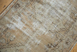Worn pile and exposed foundation of distressed Oushak runner, with muted geometric patterns.
