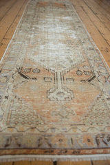 Vintage distressed Oushak runner showing faded tangerine and widespread wear to foundation.