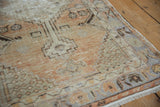Distressed Oushak runner texture: faded tangerine, slate, and charcoal geometric floral motifs.