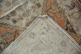 Distressed Oushak pile in faded terracotta and charcoal, showing wear and hand-knotted back.