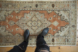 Faded burnt orange and beige distressed Turkish Oushak rug, with a scalloped medallion.