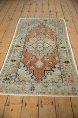 Distressed Oushak rug with playful floral border and rust scalloped medallion.