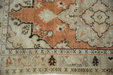 Distressed vintage Oushak rug pile with even wear, burnt orange field, and floral arabesques.