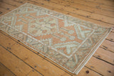 Central floral medallion on vintage Oushak runner, with dusty rust, sea foam, and even pile wear.
