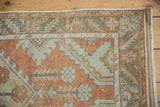 Distressed Oushak runner corner displaying rust, sea foam green, and geometric patterns.