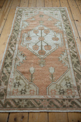 Close-up of vintage distressed Oushak rug's side cord, pale terracotta field, and charcoal border.