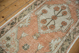 Vintage distressed Oushak rug runner showcasing pale terracotta pile and ivory floral border.