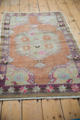 Distressed starburst floral border in violet, pink, and cream with natural fringe.