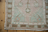Close-up of worn fringe and floral border on the vintage Distressed Oushak rug runner.