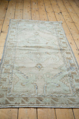 Distressed vintage Oushak rug runner showing textured pile in beige, sea foam green.