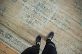 Distressed vintage Oushak rug with visible wear, foundation, and faded blue floral motifs.