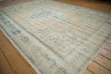 Distressed pile of vintage Oushak carpet with faded floral patterns and visible foundation.