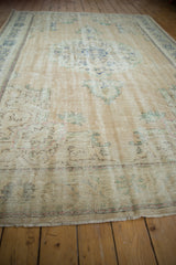 Textured detail of distressed Oushak carpet with mostly even wear and short fringe.