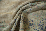 Distressed vintage Oushak carpet pile with worn texture and faded navy, beige, green motifs.