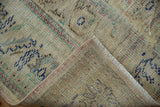 Distressed vintage Oushak pile with visible foundation, faded navy and sand, showing fringe.