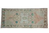Distressed Oushak runner with faded floral medallion in sand, terracotta, and turquoise. 2'9