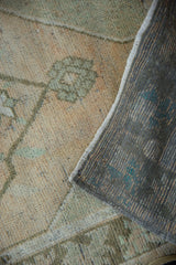 Distressed Oushak rug detail, sand, faded terracotta, dusty turquoise pile with foundation.