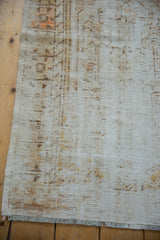 Textural distressed Oushak rug with exposed foundation, subtle ivory, saffron, and fringe.