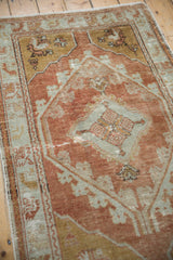 Distressed copper and pale slate floral vine details on a vintage Oushak rug.