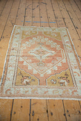 Distressed Oushak rug corner revealing copper, dusty gold, and pale silver slate tones with aged texture.