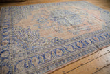 Distressed traditional Oushak rug, showing worn rococo leaves in dusty blue and pale sandalwood.