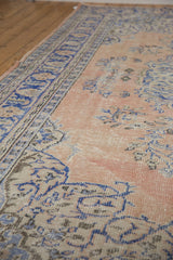 Textured distressed Oushak rug showing pale sandalwood and brilliant denim blue floral details.