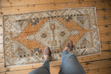 Vintage distressed Oushak runner with diamond medallion, serrated floral accents, and copper, charcoal, silver tones.