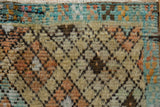 Distressed vintage Tulu rug texture, revealing visible knot heads, beige, blue, and tangerine tones.