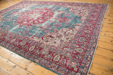 Angled perspective of a distressed Sivas rug highlighting its cherry red medallion and ocean blue field.
