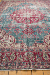 Textured pile of a distressed Sivas carpet with cherry red and ocean blue floral motifs.