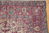 Intricate scrolling arabesques on the distressed corner borders of a vintage Sivas carpet.
