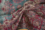 Worn, low-pile texture on a distressed Sivas carpet with cherry red and ocean blue florals.