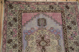 Stylized tree motif with violet stepped design and mauve hues on a distressed vintage Oushak runner.