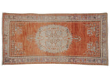 Vintage distressed Oushak rug runner, terracotta abrashed field, faded floral medallion. 3'4