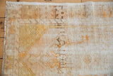 Close-up of worn knot heads and exposed ivory foundation on a distressed vintage Oushak rug.