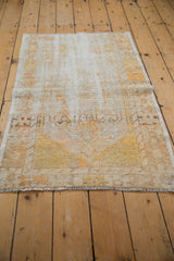 Low-angle view along the length of a distressed vintage rug, showing its textural wear.