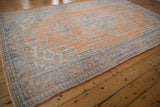 Worn terracotta orange and faded royal blue distressed Oushak carpet texture.