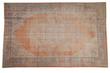 Distressed vintage Oushak rug, pale rust orange center medallion with faded ivory and blue florals.