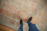 Distressed Oushak rug pile with prominent wear revealing pale rust, ivory, and blue details.