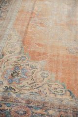Distressed Oushak rug showing worn pile texture, pale rust, and faded blue motifs.